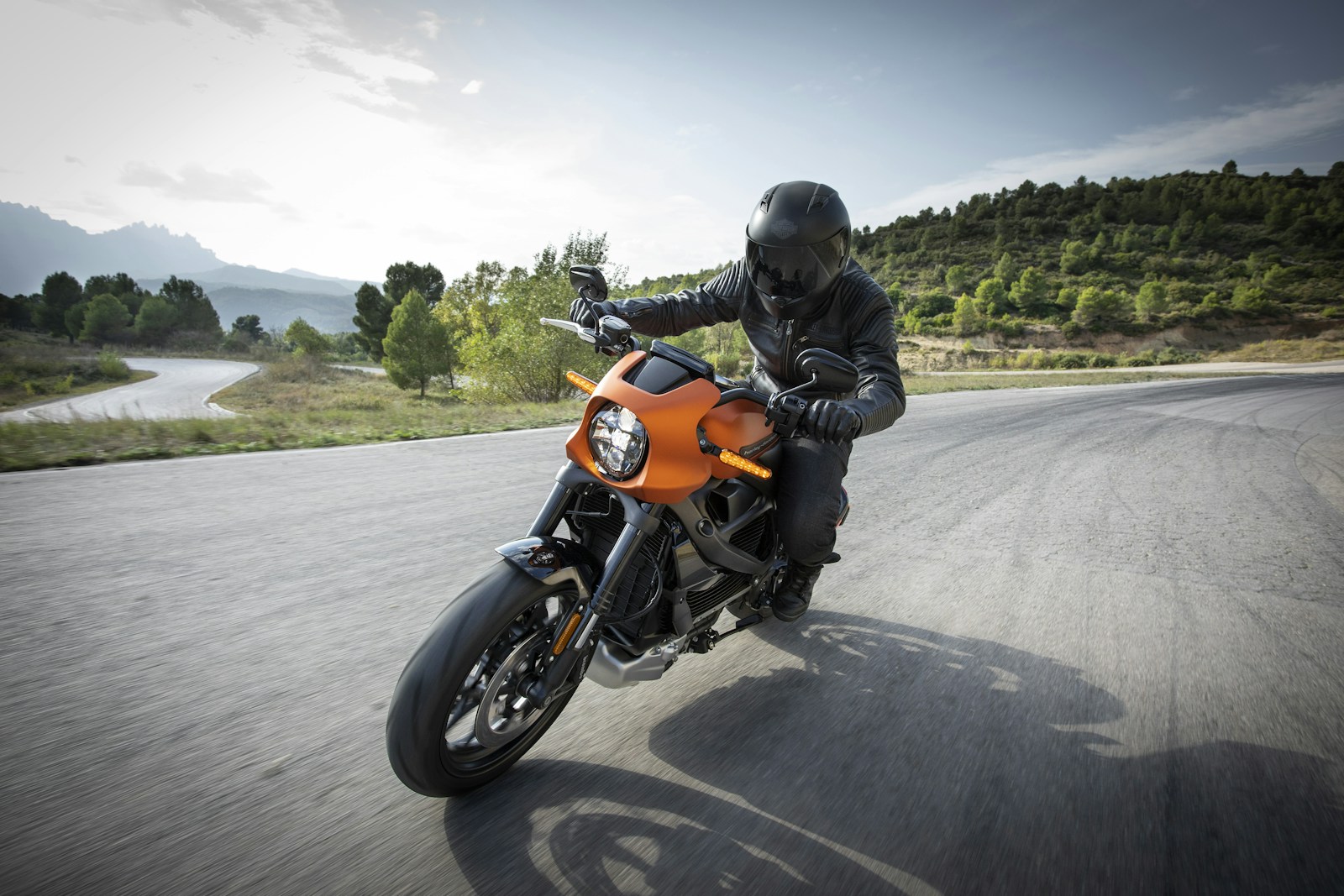 person driving orange motorcycle; young entrepreneurs rethinking commute