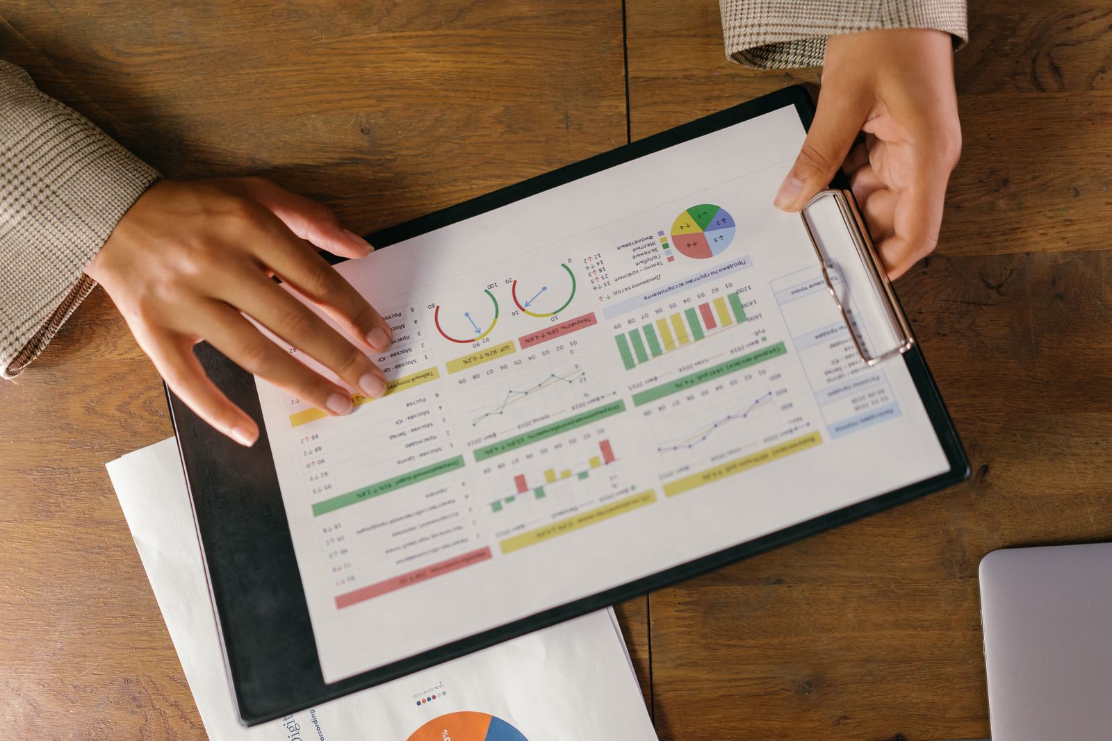 Top view of hands holding a financial report with colorful graphs and charts, ideal for business presentations; entrepreneurs protect business assets